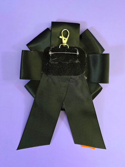 the back of the ribbon has a pin back and a keychain clip.