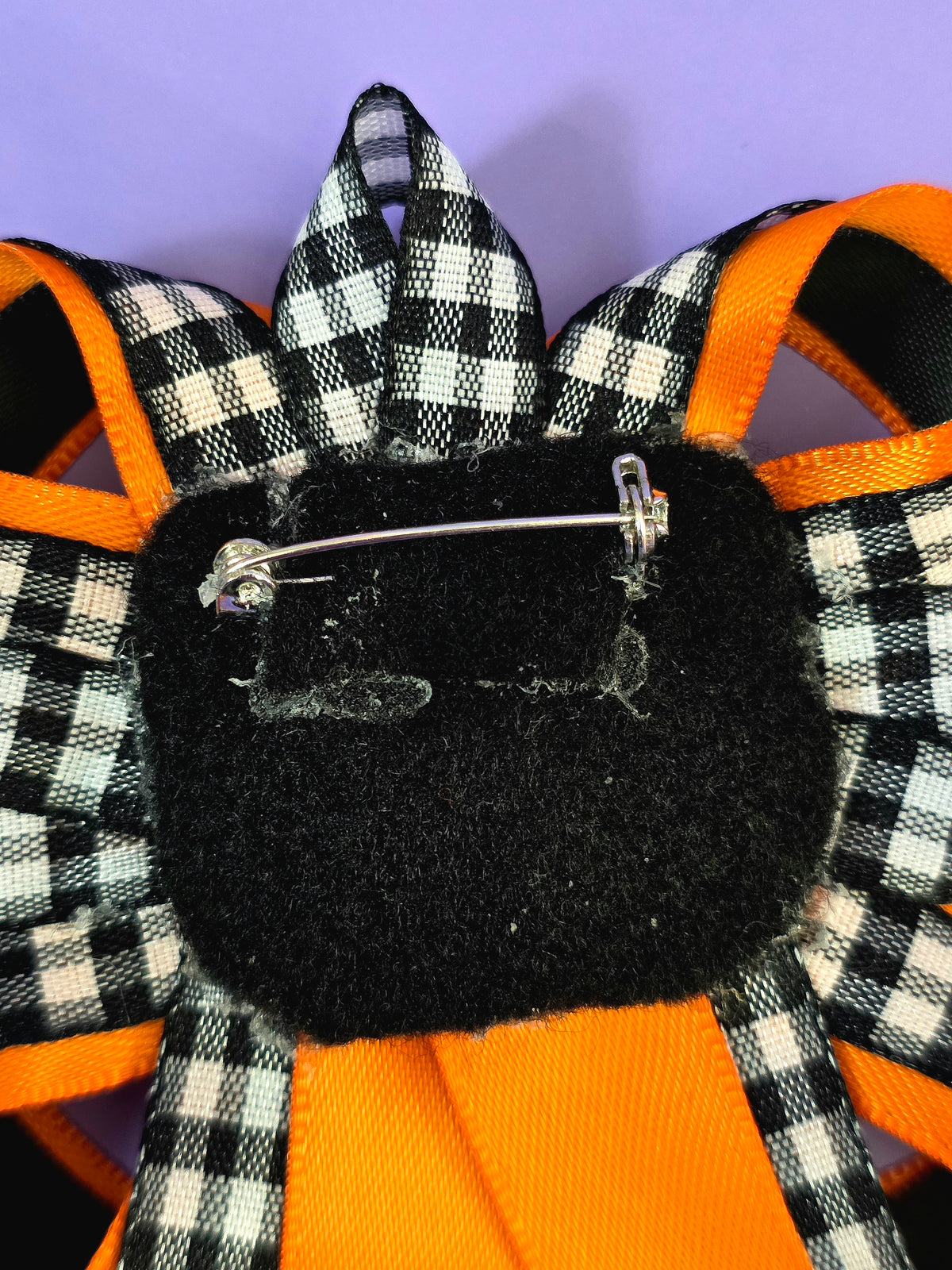 the back of the prize ribbon has a pin back attached to it.