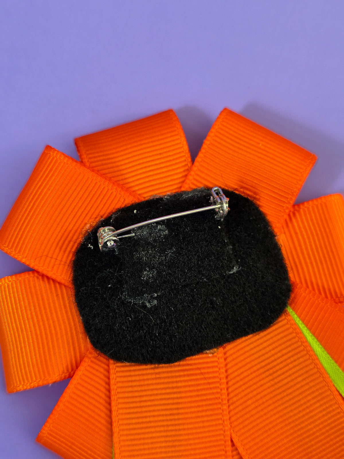 the back of the prize ribbon has a pin back glued onto black felt.