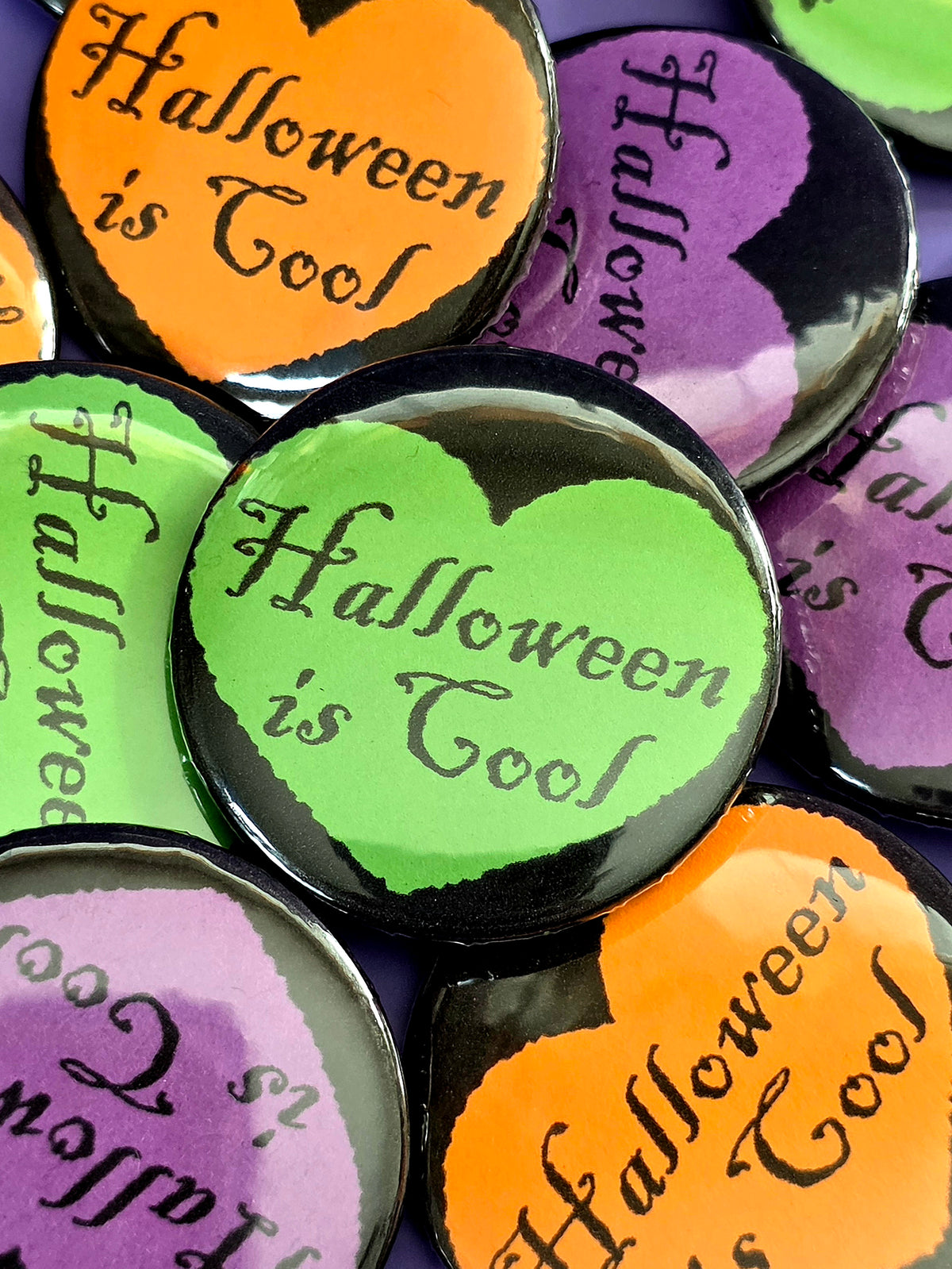 a green button that says "Halloween is cool" with a black heart around it