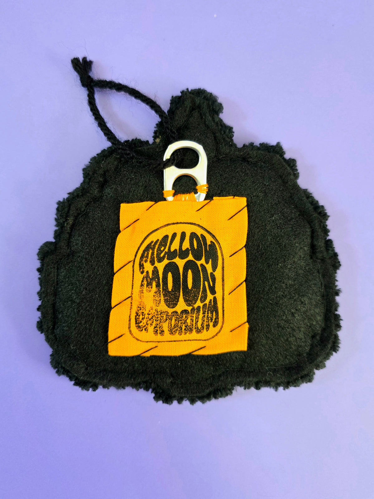 the back of the small pumpkin wall hanging has an orange tag that says mellow moon emporium hand sewn onto black premiun felt. There is a soda tab sewn on for you to hang this piece on.