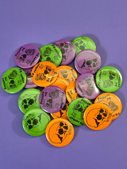a pile of buttons, some say "I'd rather be rotting" with  skull with heart eyes and fungi coming out of it and some just have skulls  with heart eyes on them